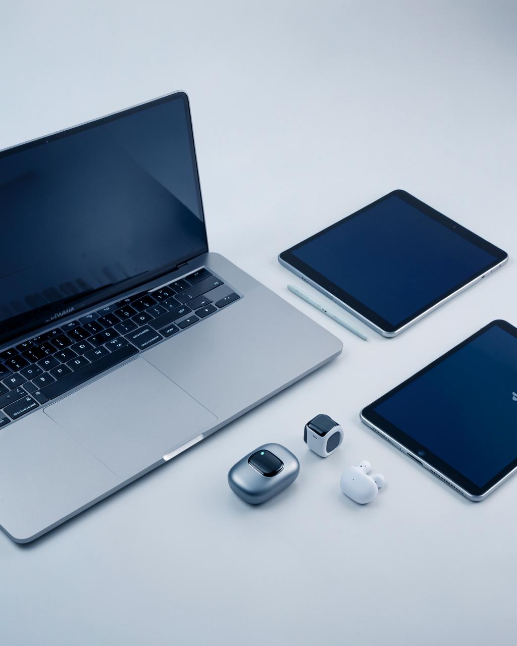 Curated gadget showcase with laptop, earbuds, and smart devices